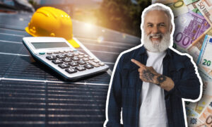 Un propriétaire qui montre une calculatrice posée sur des panneaux solaires photovoltaïques