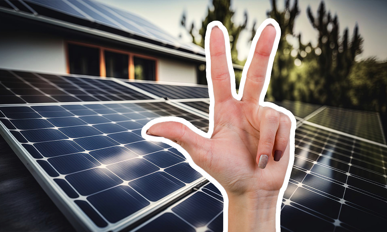 Main faisant le signe 3 devant des panneaux solaires sur le toit d'une maison